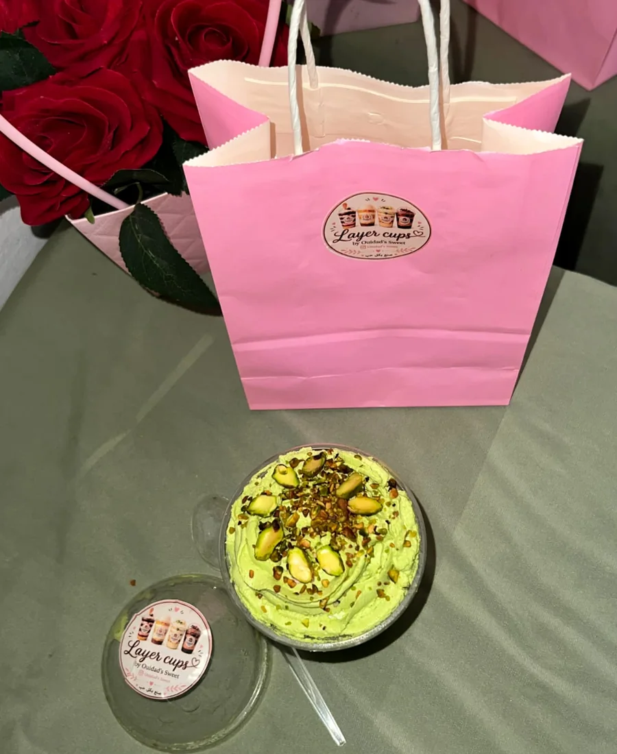 Layer Cup Pistache ouvert devant un sac rose et des roses rouges